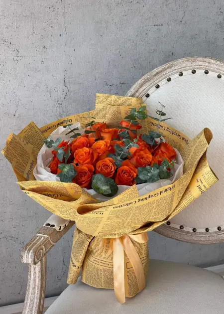 Vibrant Orange Roses Vintage Newspaper Wrap Dubai | باقة جوري برتقالي نابضة بتغليف ورق الصحف القديم دبي