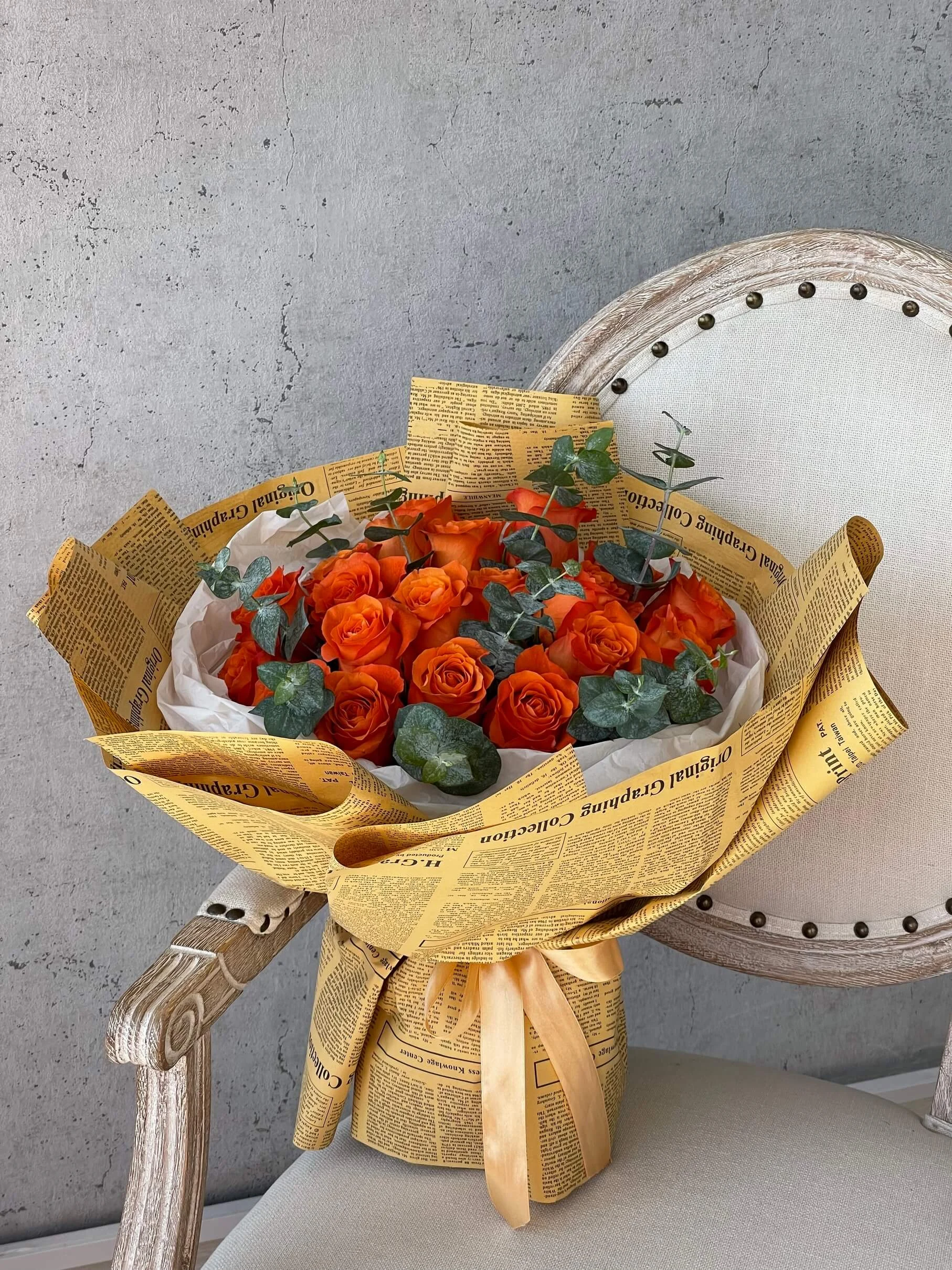 Vibrant Orange Roses Vintage Newspaper Wrap Dubai | باقة جوري برتقالي نابضة بتغليف ورق الصحف القديم دبي